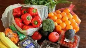 Varietà di frutta e verdura fresca sistemate su un tavolo di legno