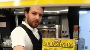 Una persona mostra un biglietto gratta e vinci all'interno di un bar