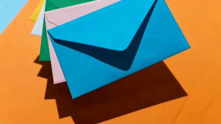 Buste colorate sovrapposte su sfondo arancione, simbolo del metodo delle buste per risparmiare