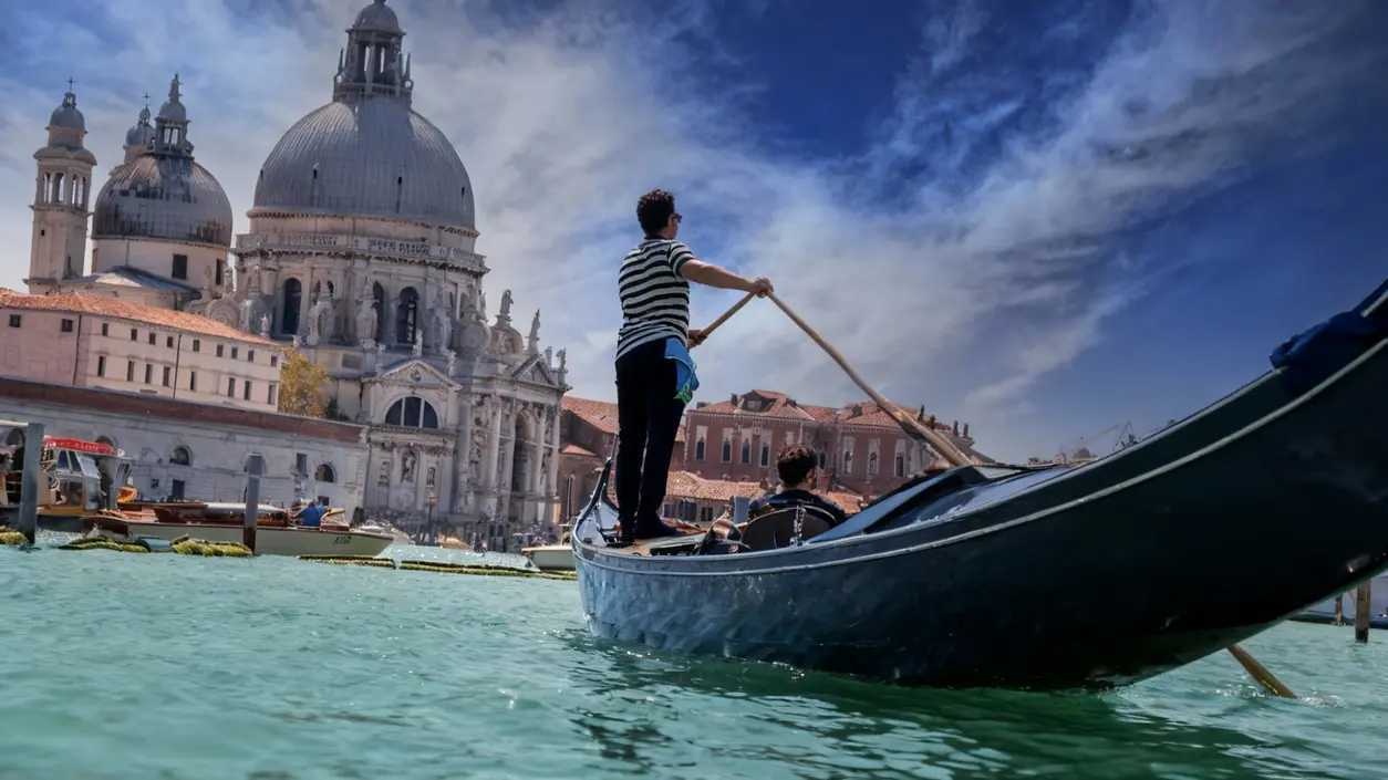 Gondola con due persone sul Canal Grande a Venezia davanti alla Basilica di Santa Maria della Salute