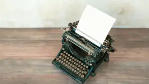 Vecchia macchina da scrivere su un tavolo di legno con un foglio inserito