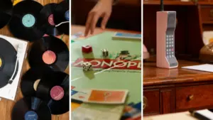 Oggetti vintage tra cui vinili, un gioco da tavolo e un vecchio telefono su una scrivania